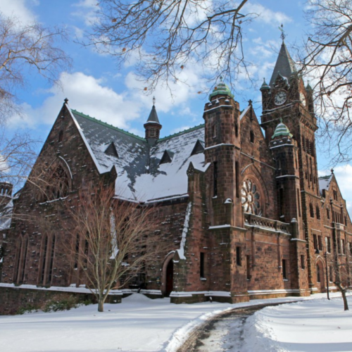 New England-style brick building with steeples. Snow on roof.